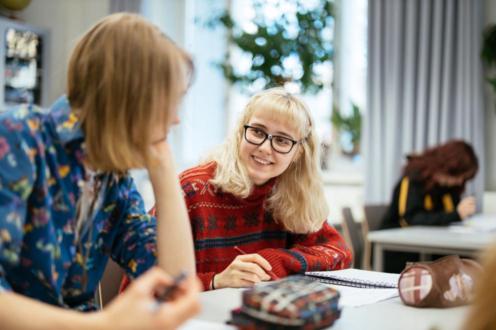 Helsinki material bank / Jussi Hellsten Kaksi nuorta opiskelee pöydän ääressä luokkahuoneessa.