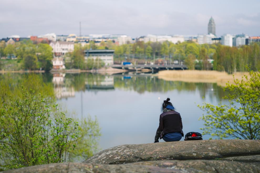 Nainen istuu kalliolla. Kuvaaja: Jussi Hellsten